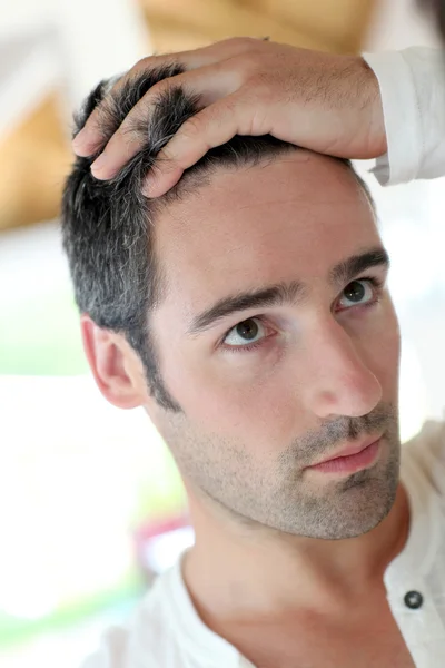 Homem em frente ao espelho a olhar para o cabelo — Fotografia de Stock