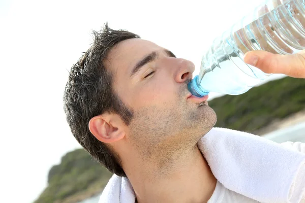 ジョガーは運動をした後水を飲む ストック画像