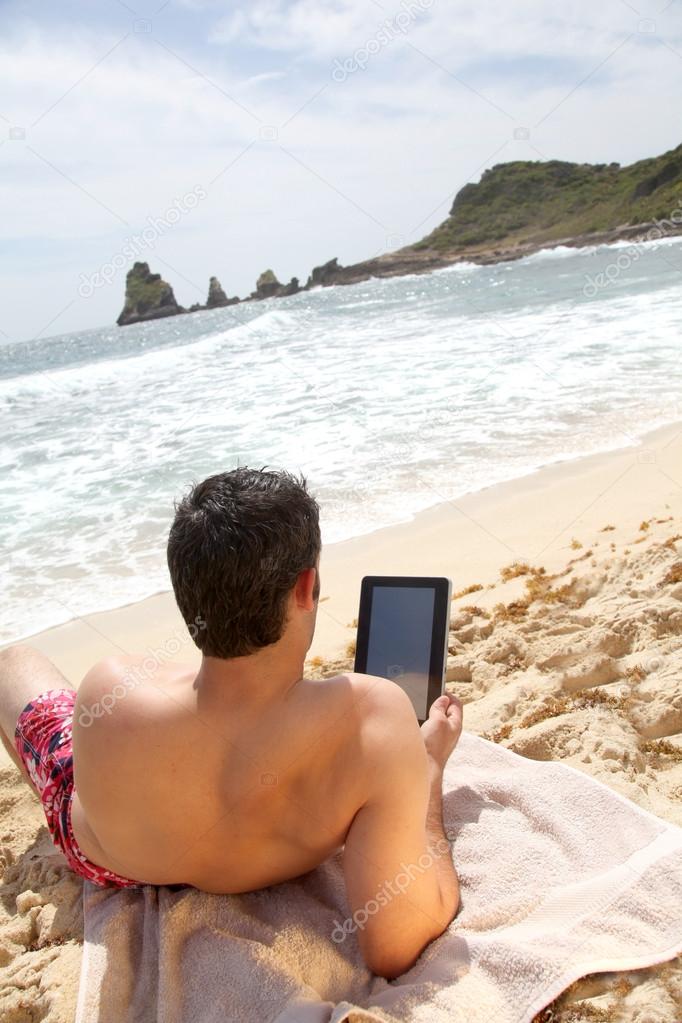 Man using electronic tablet on the beach