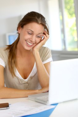 dizüstü bilgisayarınızda evde çalışan gülümseyen kadın portresi