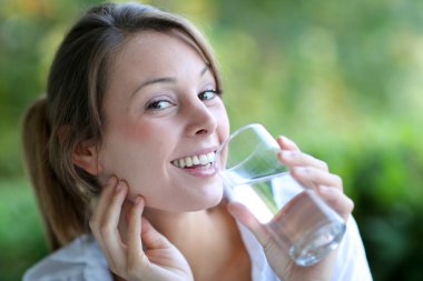 Smiling woman drinking fresh water from glass