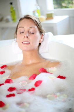 güzel kadın rahatlatıcı banyo gül yaprakları ile