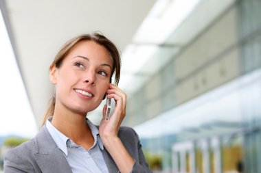 Mobil telefonda konuşurken gülümseyen iş kadını