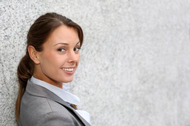 gülümseyen executive gri duvara yaslanmış