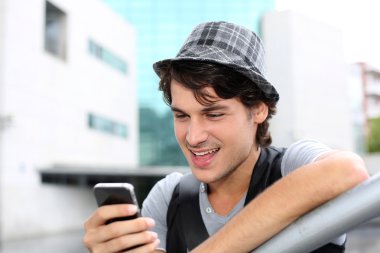 Portrait of young guy sending message with smartphone clipart