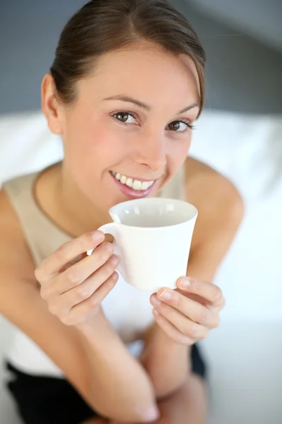 Belle femme relaxante dans un canapé avec une tasse de thé — Photo