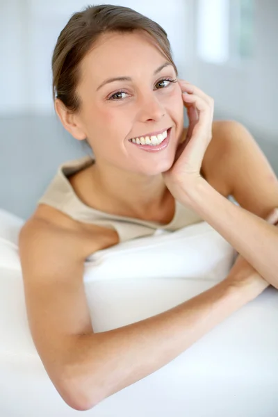 Beautiful smiling woman relaxing in sofa — Stock Photo, Image