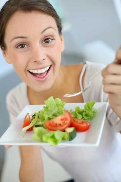 Крупный план веселой женщины, поедающей свежий салат — стоковое фото