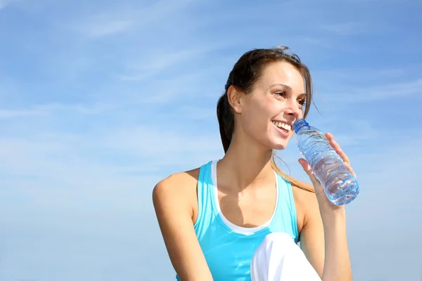 Törstig fitness tjej hålla flaska vatten — Stockfoto