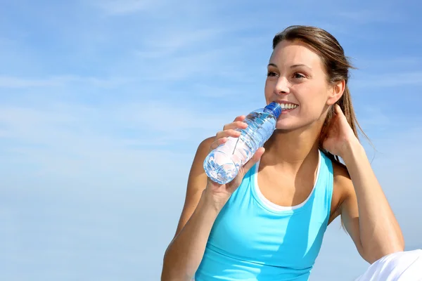 Törstig fitness tjej hålla flaska vatten — Stockfoto