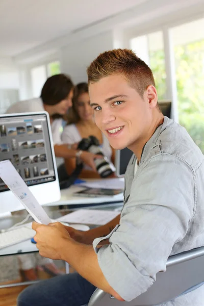 Young man sitting in office in front of desktop computer — Stock Photo, Image