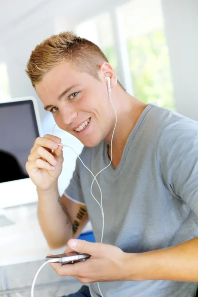 Студент слушает музыку с mp3 плеером — стоковое фото