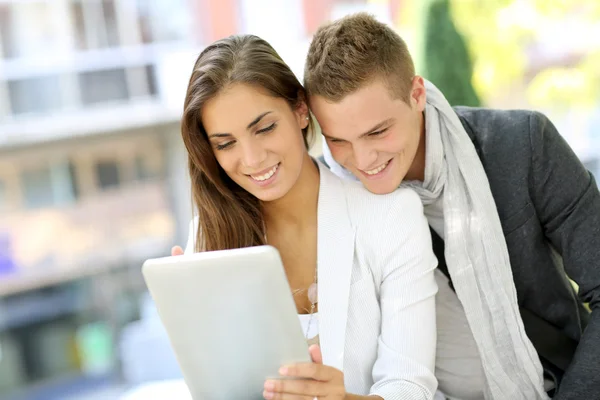 Pareja joven de moda en la ciudad usando tableta — Foto de Stock