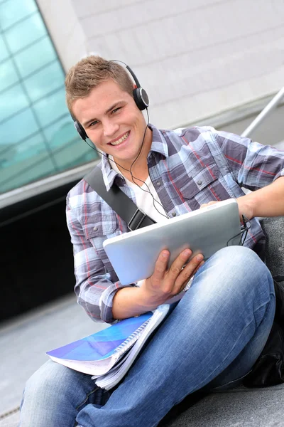 Estudiante universitario usando tableta digital y auriculares —  Fotos de Stock