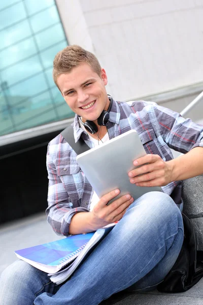 Estudante universitário usando tablet digital e fones de ouvido — Fotografia de Stock