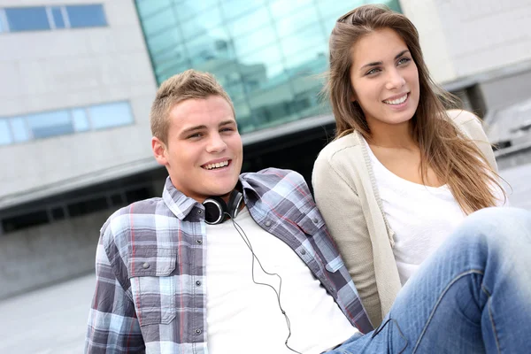 若いカップルが大学の建物の外に座って — ストック写真