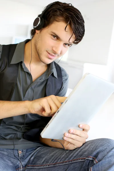 Stilig kille lyssna på musik på internet med tablett — Stockfoto
