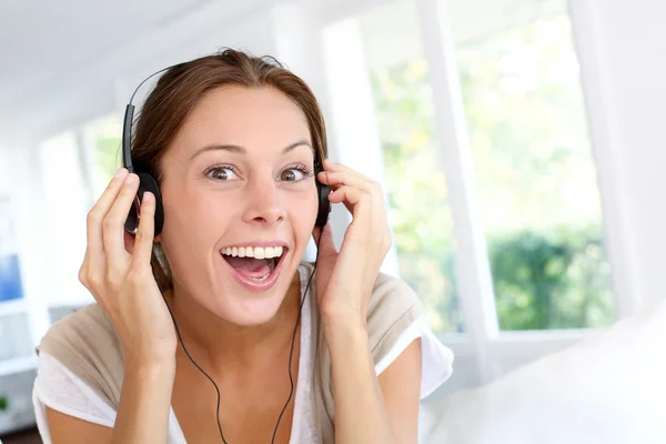 Wesoła, młoda kobieta, słuchanie muzyki w słuchawkach — Zdjęcie stockowe