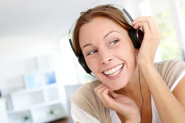 Joven alegre escuchando música con auriculares —  Fotos de Stock