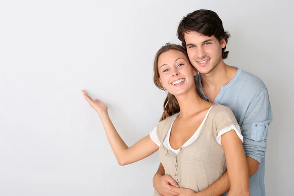 Young couple on white background designating message — Stock Photo, Image