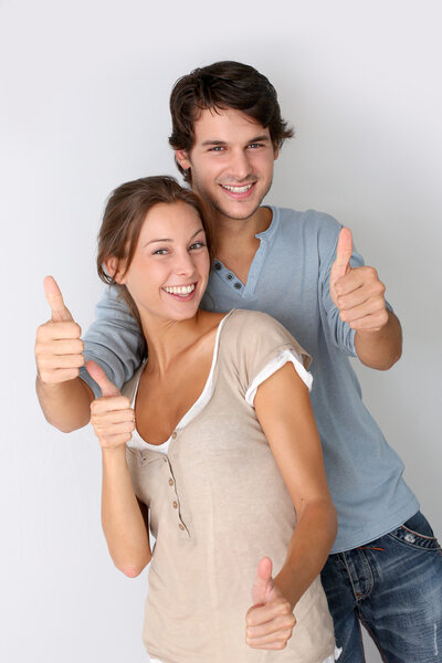 Cheerful couple showing thumbs up, isolated
