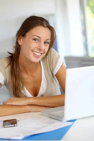 Portret van lachende vrouw die op laptop thuis werkt — Stockfoto