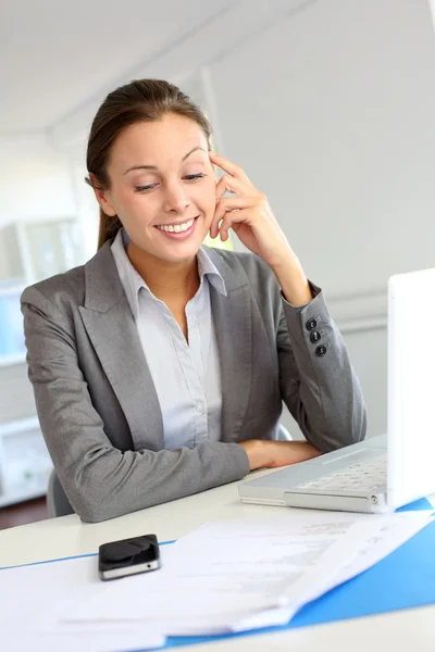 Femme d'affaires souriante assise à son bureau — Photo