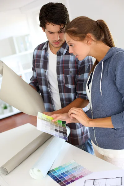 Casal procurando a melhor cor de papel de parede — Fotografia de Stock