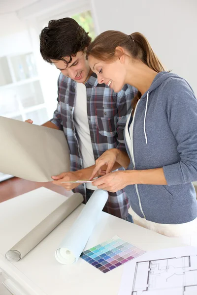 Pareja buscando el mejor color de fondo de pantalla — Foto de Stock