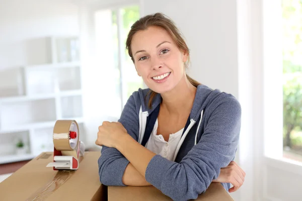 Leende ung kvinna packning lådor att flytta ut — Stockfoto