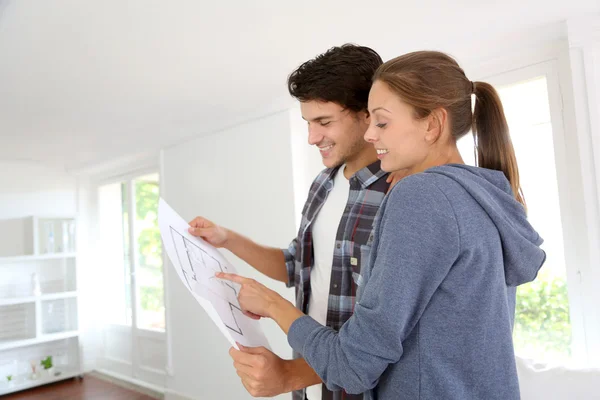 Nuevos propietarios mirando el plano de su casa —  Fotos de Stock