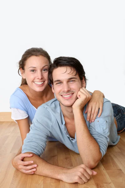 Couple joyeux couché plancher de bois — Photo