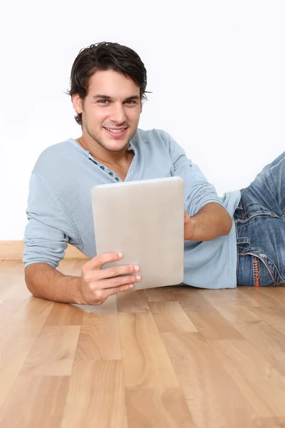 Ung man på golvet med digitala tablett — Stockfoto