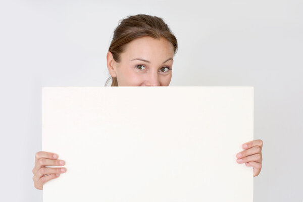 Closeup of woman hiding behind whiteboard