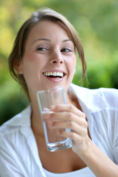 Lachende vrouw drinken vers water uit glazen — Stockfoto