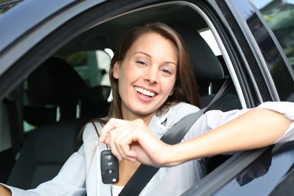 Menina alegre segurando chaves do carro da janela — Fotografia de Stock