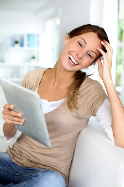 Jonge vrouw met behulp van elektronische tablet zittend op de Bank — Stockfoto