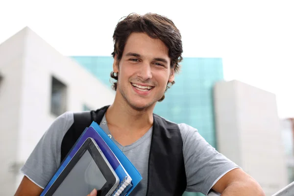 Estudiante alegre parado fuera del edificio de la universidad — Foto de Stock