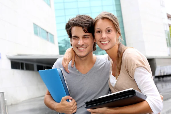 Alegre pareja de estudiantes de pie en el campus universitario — Foto de Stock