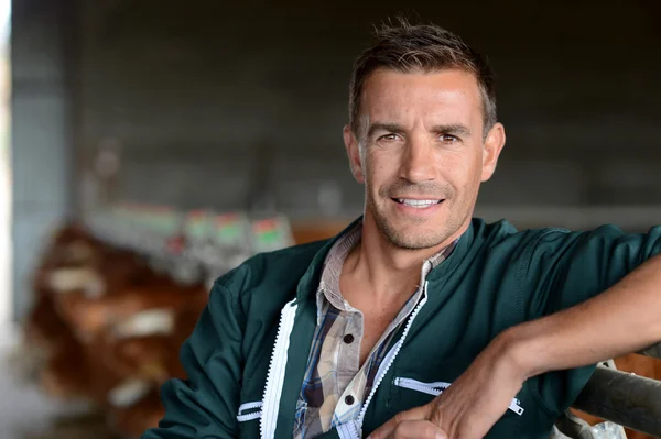 Portrait of smiling herdsman standing in barn — Stock Photo, Image