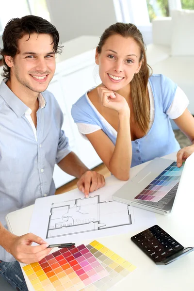 Pareja eligiendo colores de pintura para su nuevo hogar Imágenes de stock libres de derechos