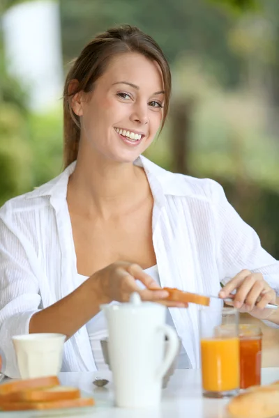 Young woman having bread for breakfast Stock Picture