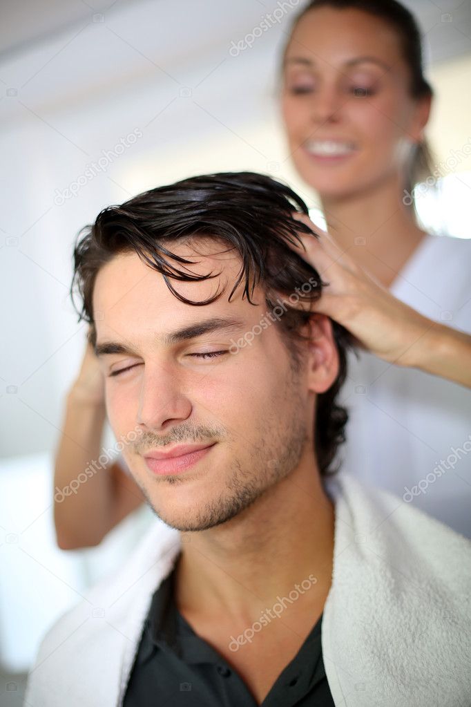 Hairdresser doing head massage to customer