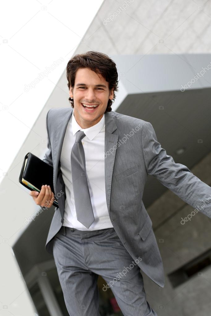 Happy successful businessman jumping in the air