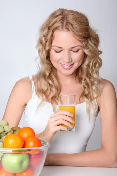 Schöne blonde Frau trinkt Fruchtsaft — Stockfoto