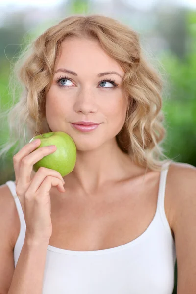 Retrato de una hermosa mujer comiendo manzana verde — Foto de Stock