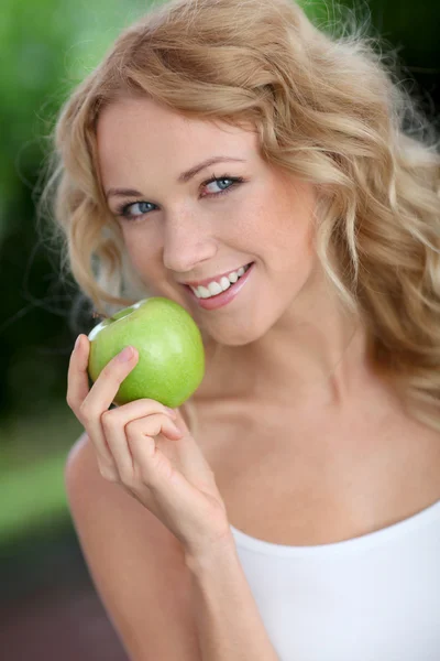 Retrato de una hermosa mujer comiendo manzana verde — Foto de Stock