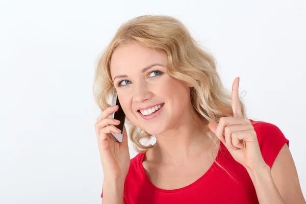 Portret van blonde vrouw met rode shirt met behulp van mobiele telefoon — Stockfoto