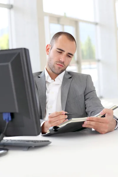 Geschäftsmann im Amt schreibt Tagesordnung — Stockfoto