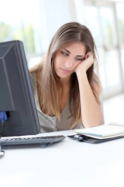 Wyczerpany młoda kobieta siedzi przed komputerem — Zdjęcie stockowe